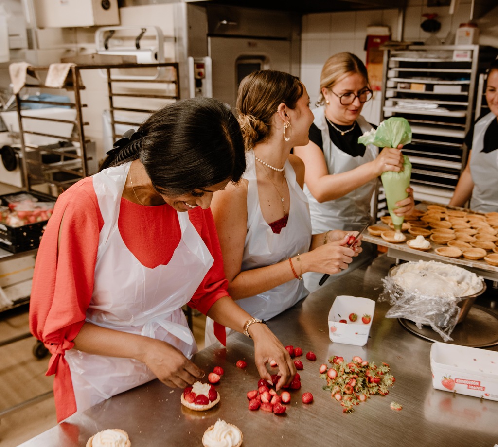 Workshops & Team-Events Teilnehmende an einem Schloss-Beck-Backworkshop dekorieren gemeinsam kleine Gebäckstücke.